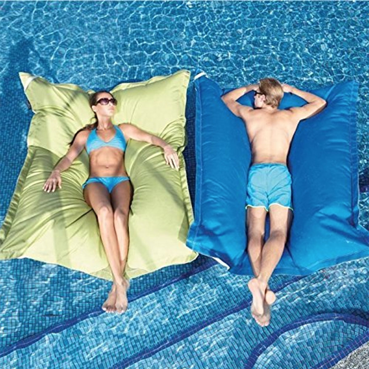 adults laying on large bean bag pool floats in pool