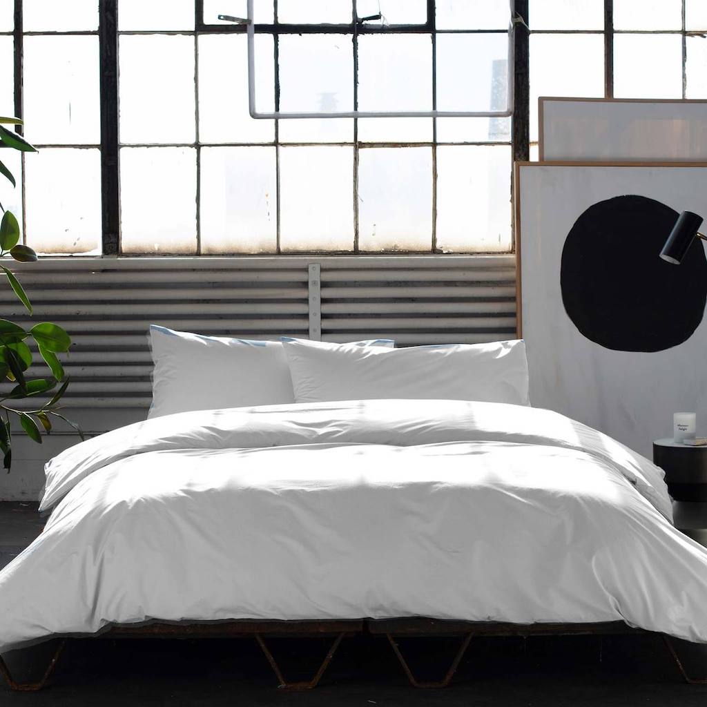 bed made with white sheets 
