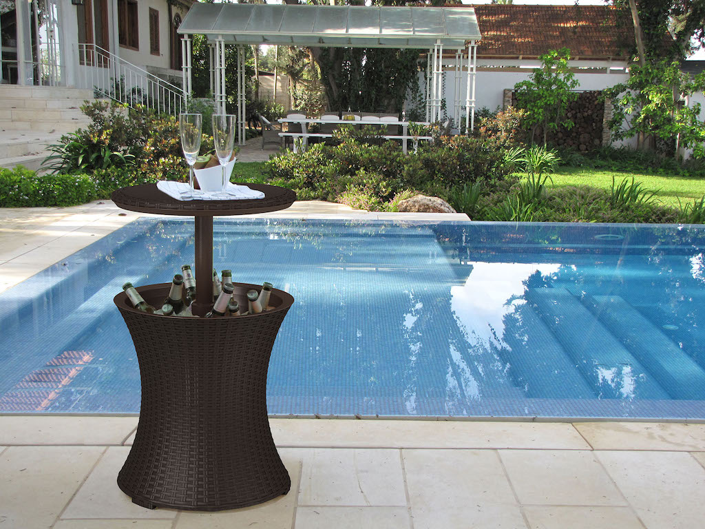 brown cooler table with drinks by pool