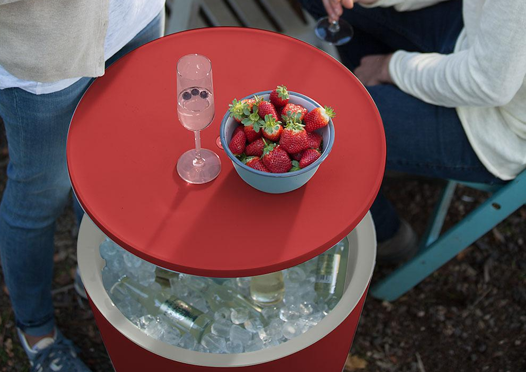 red cooler table with ice, drinks, wine and strawberries