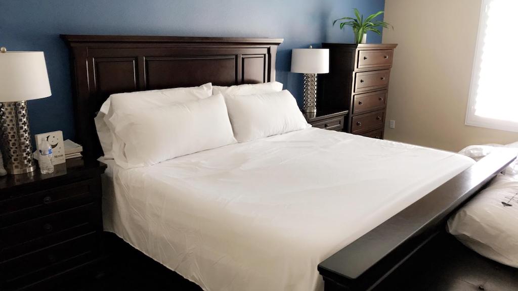 queens size bed made with white sheets 