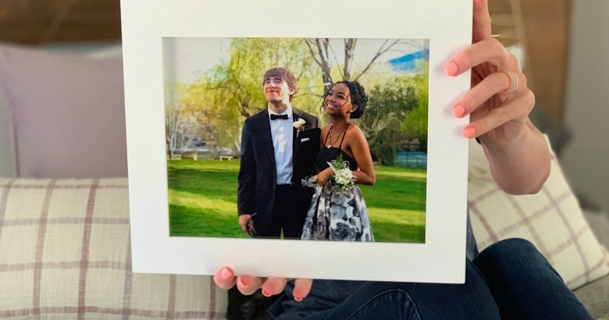 holding framed prom photo 