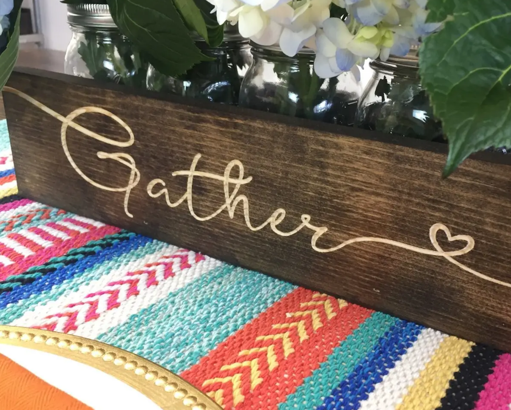 wood centerpiece with the word "Gather" written
