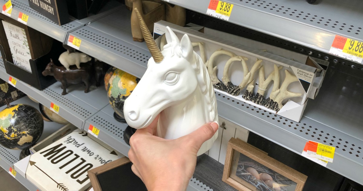 holding Unicorn home decor at Walmart 