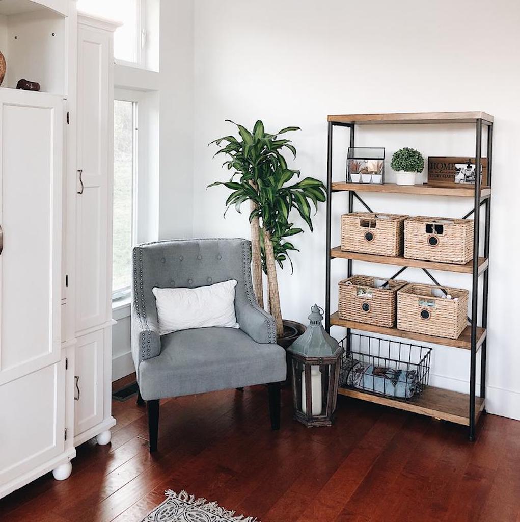 industrial bookshelf with baskets and chair in entryway 