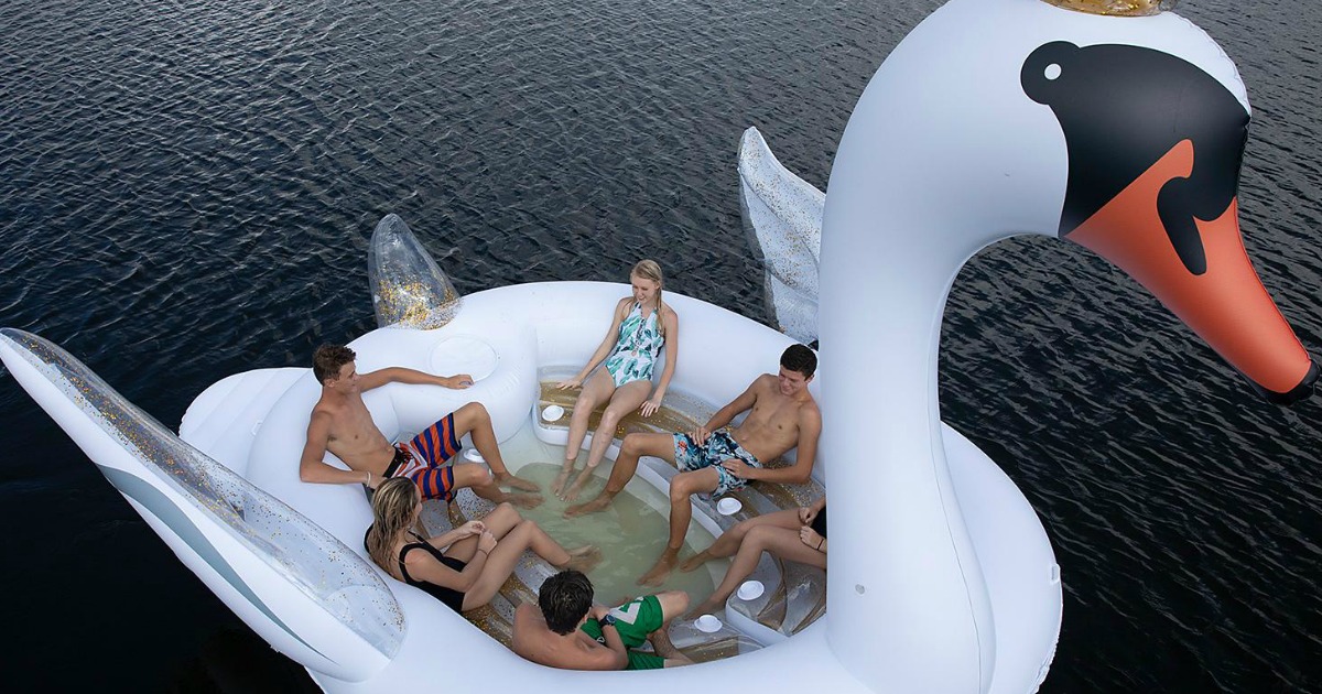 large swan inflatable with teens inside on the water 