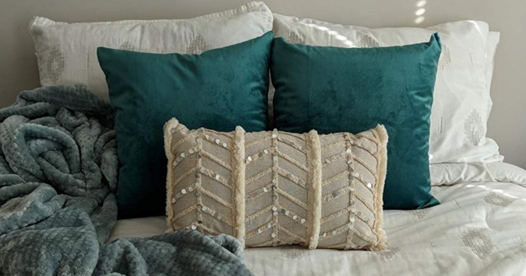 suede throw pillows on bed with blanket