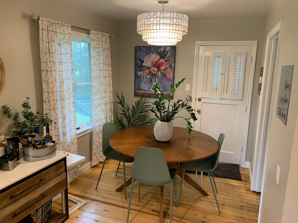 small dining room with a table, chairs, and plants 