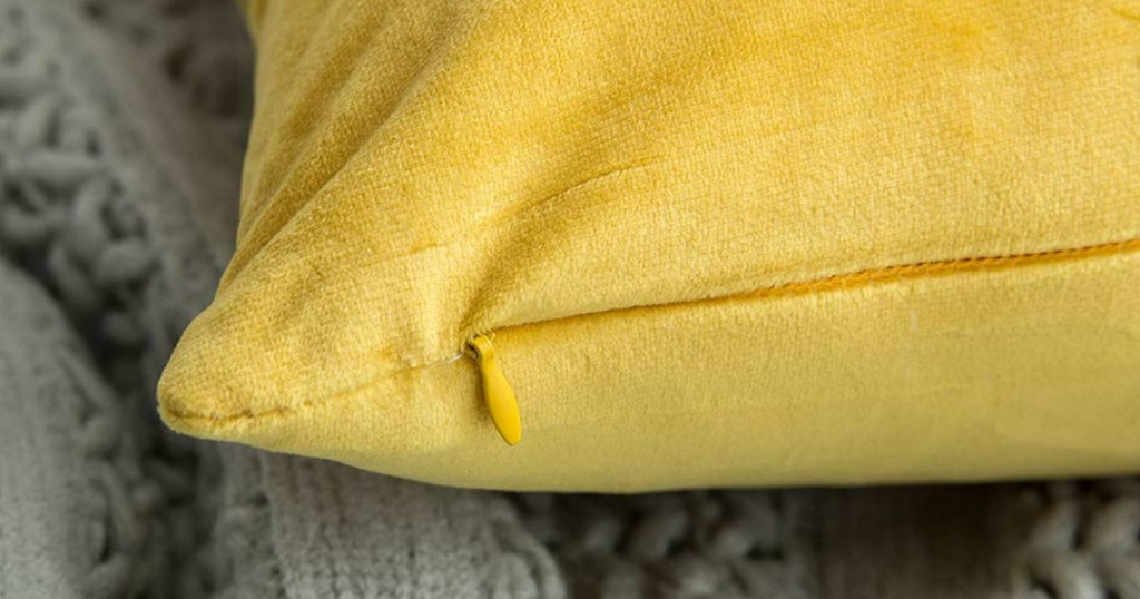 close up of yellow suede pillow with zipper
