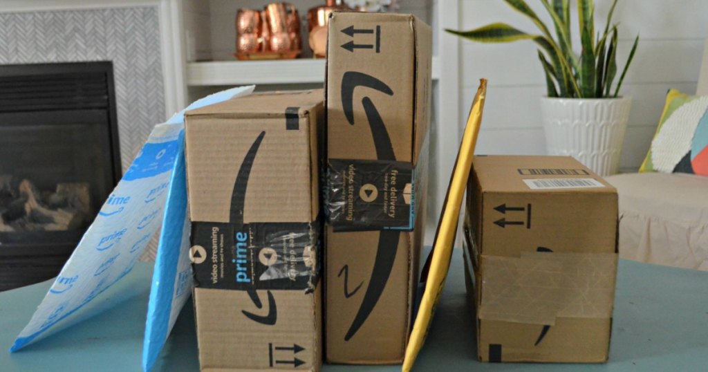 Amazon Prime boxes on dining table with plant and fireplace in the background 