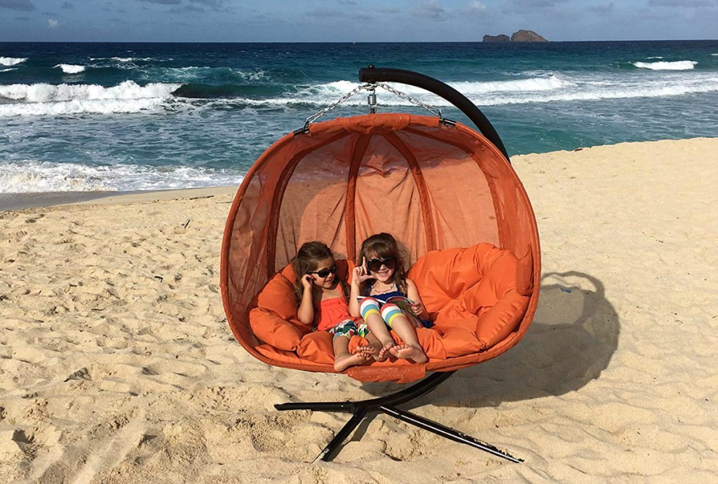 girls sitting in Flowerhouse Pumpkin Double Swing Chair with Stand on beach