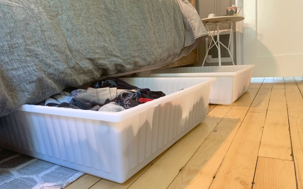 storage bin with clothing under bed
