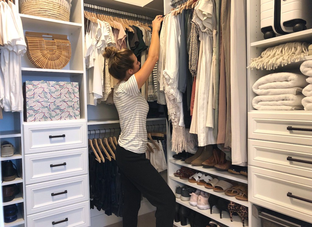 woman standing inside organized closet