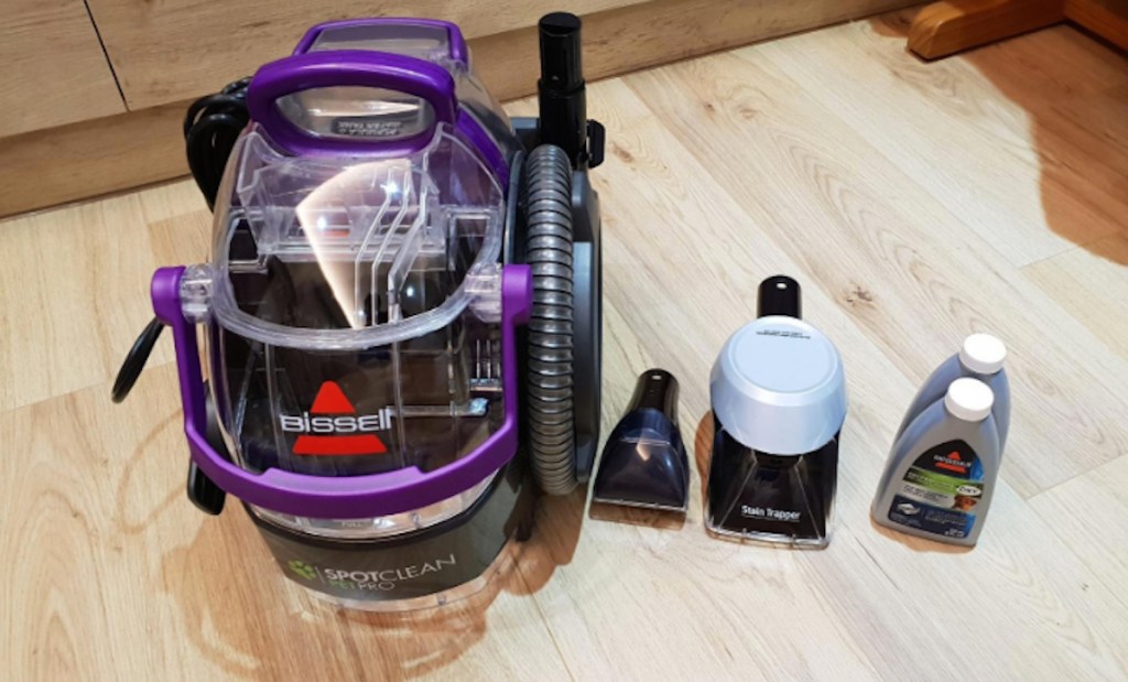 purple bissell spot clean vacuum sitting on wood floor