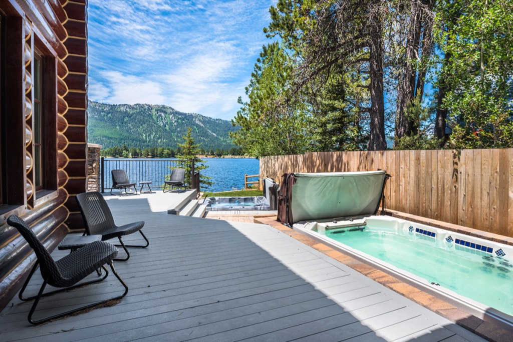 chairs sitting on deck by hot tub and lake