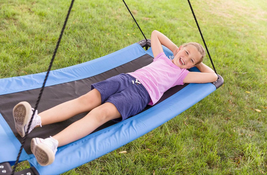 girl laying back on blue swing