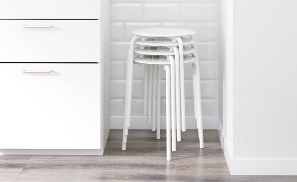 white stackable stools in corner