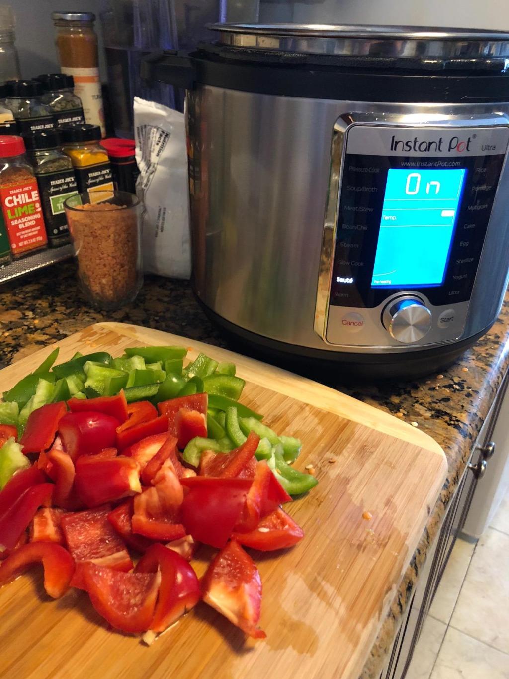 Instant Pot pressure cooker in kitchen next to cutting board with veggies 