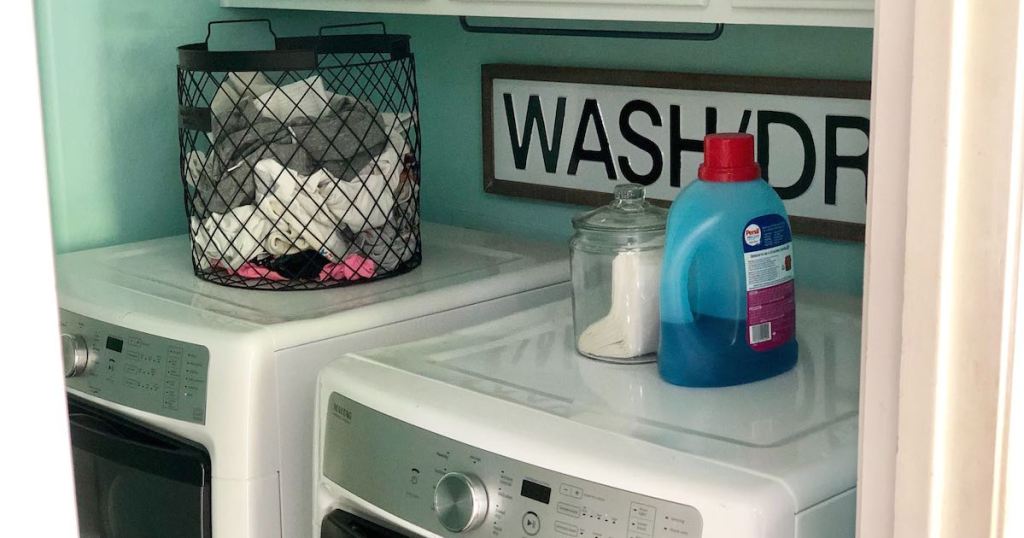 laundry room with basket and soap on washer and dryer