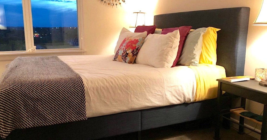 Modern bed frame with bed made and pillows 