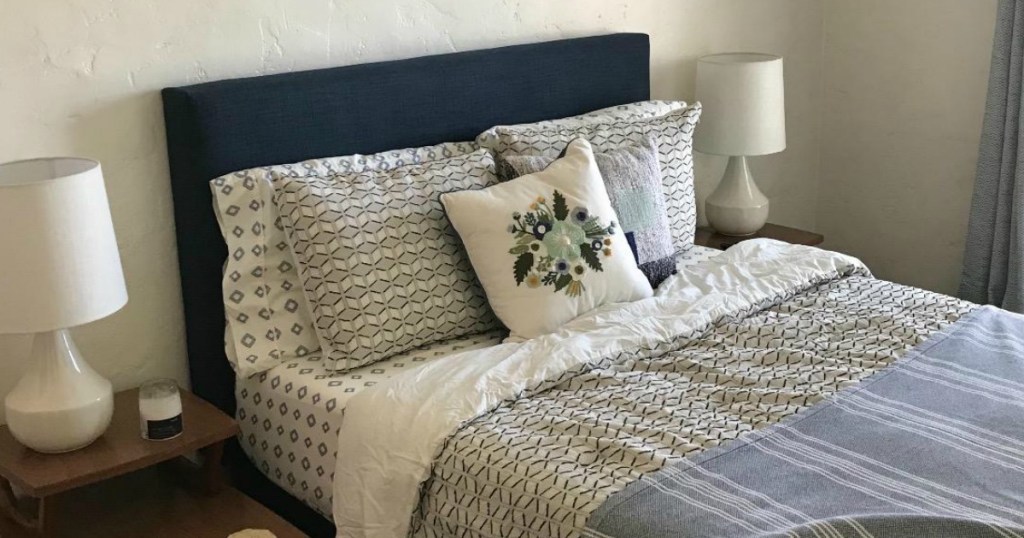 Navy platform bed with bedding and throw pillows 