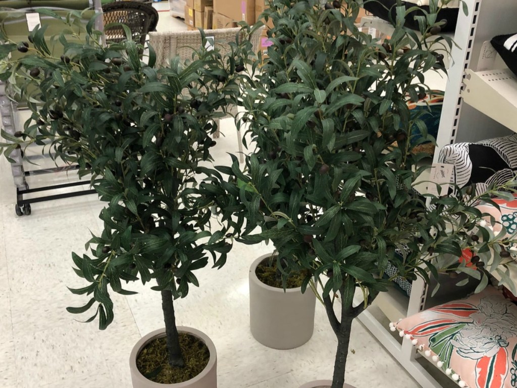 three fake trees sitting on store floor