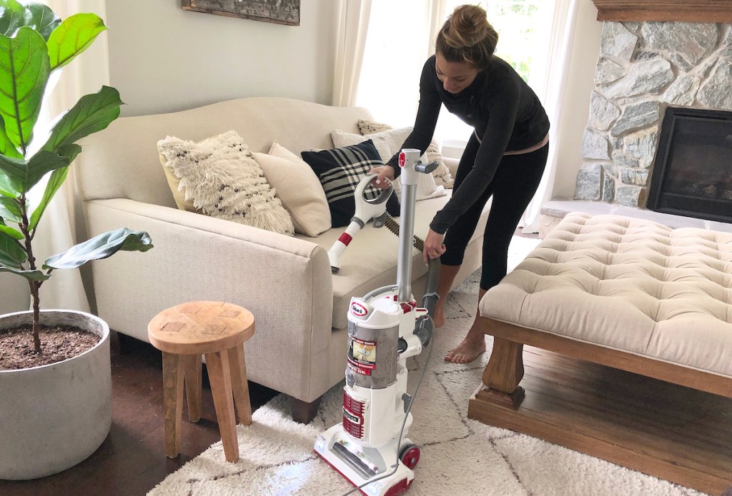 woman vacuuming couch living room