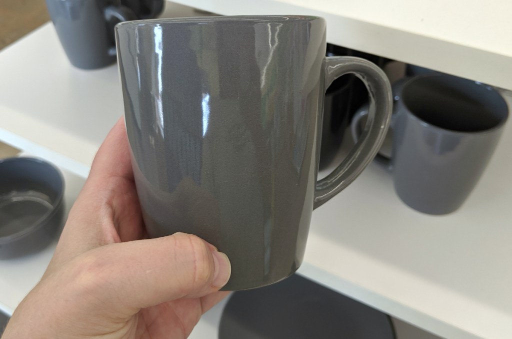 person holding gray mug