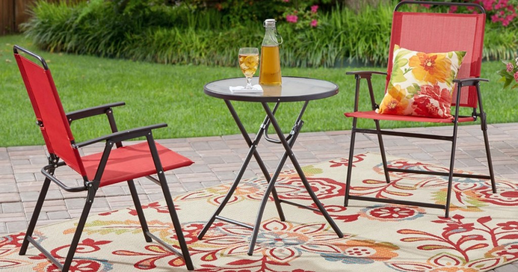 3-piece bistro set in red on outdoor rug in backyard