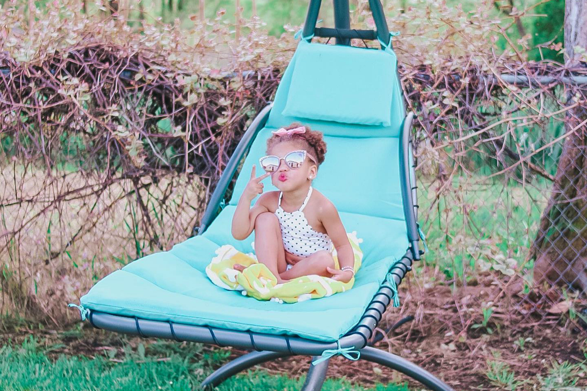 small girl sitting on blue lounge chair