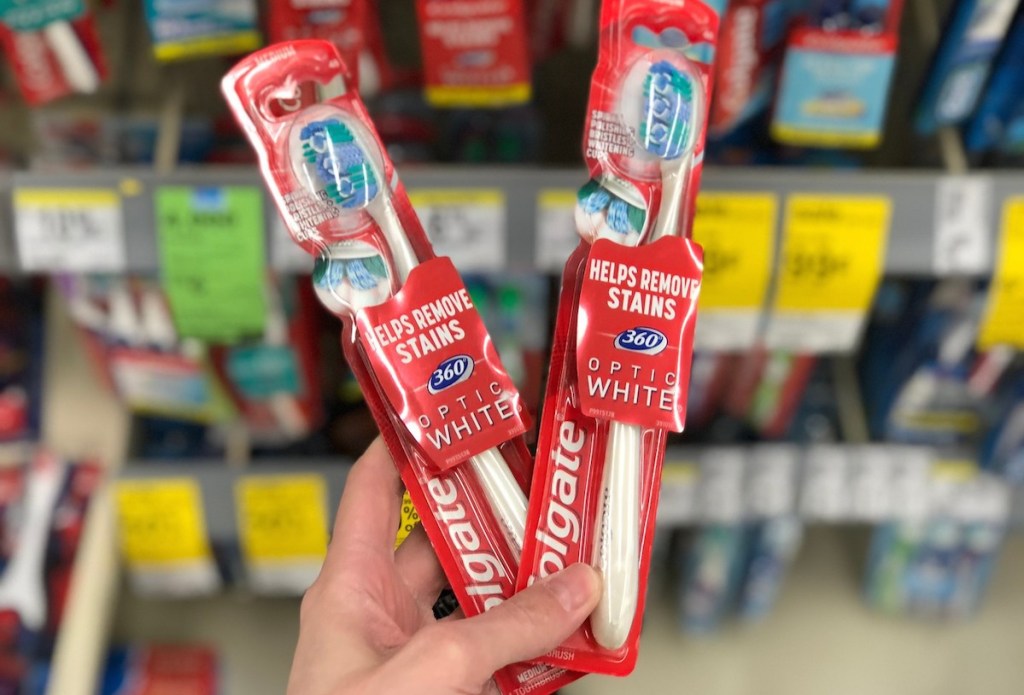 hand holding two toothbrushes in new packaging