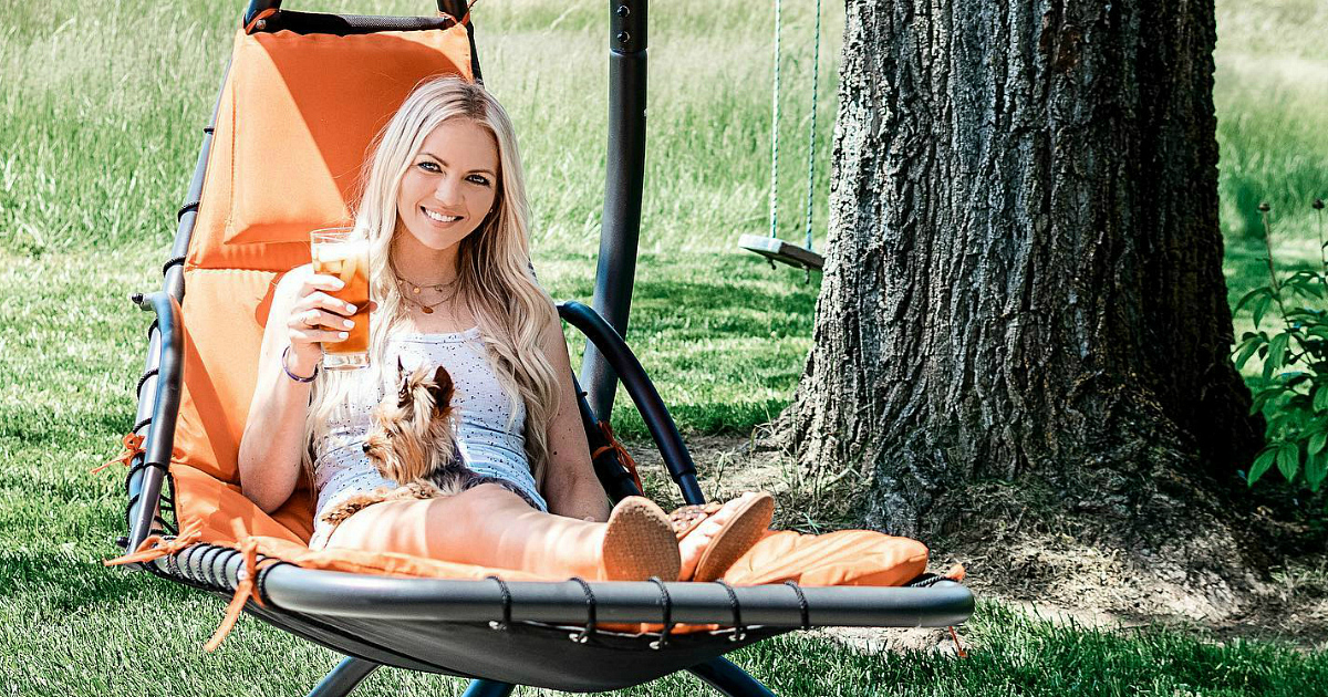 woman sitting on lounge chair with dog